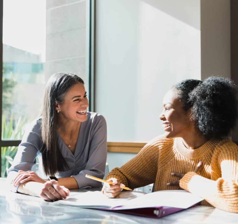 Caring female high school teacher tutors female student secure admissions testing